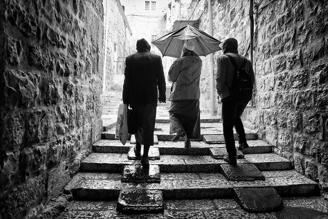 People climbing steps in a stone passage.